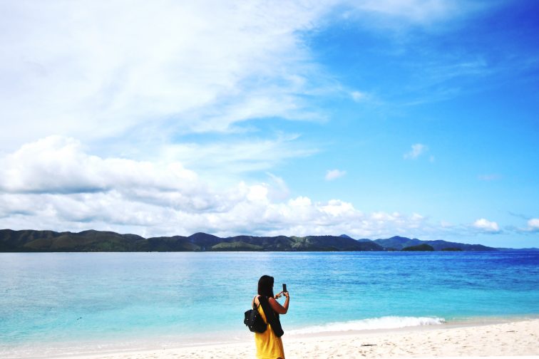 a girl taking pictures on the beach