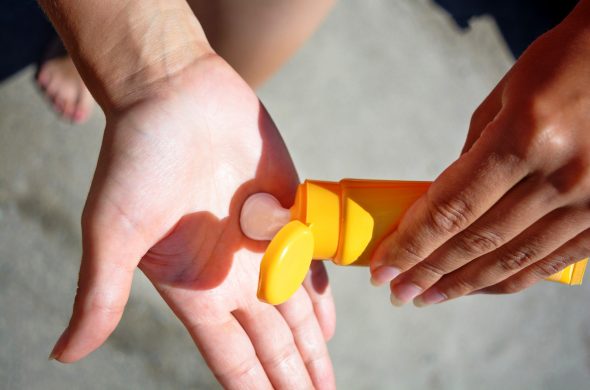 Female hands with sun protection cream. Skin care concept.