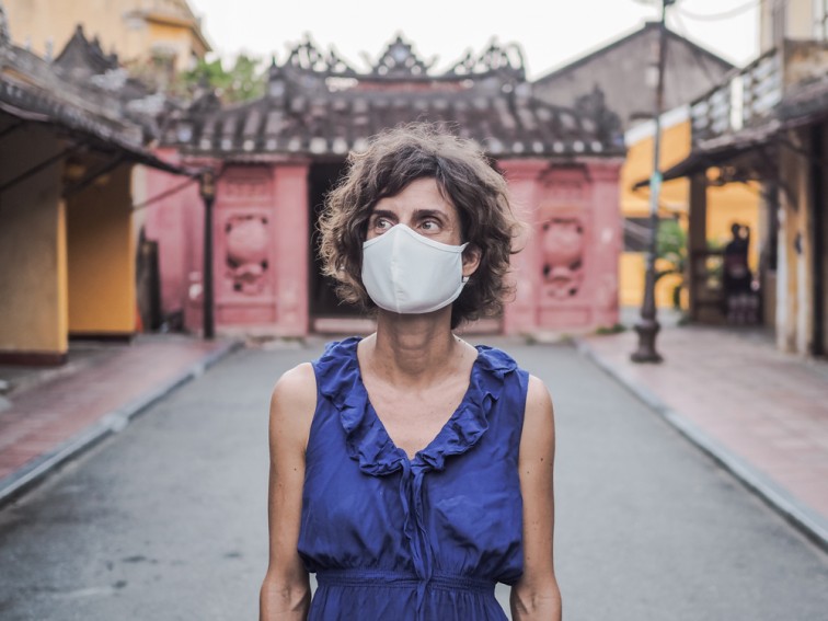 ベトナム観光地ホイアンでマスクを付けて立っている欧米人女性