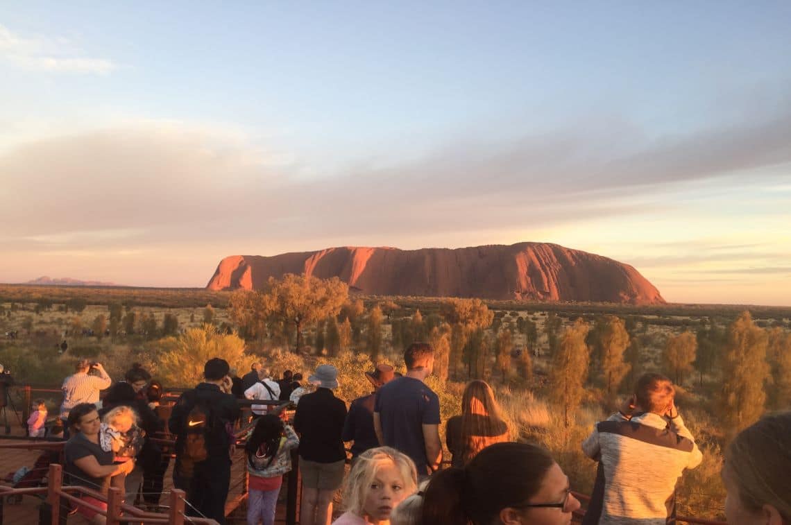 日の出に照らされるエアーズロックを見ようと各国の人が訪れる