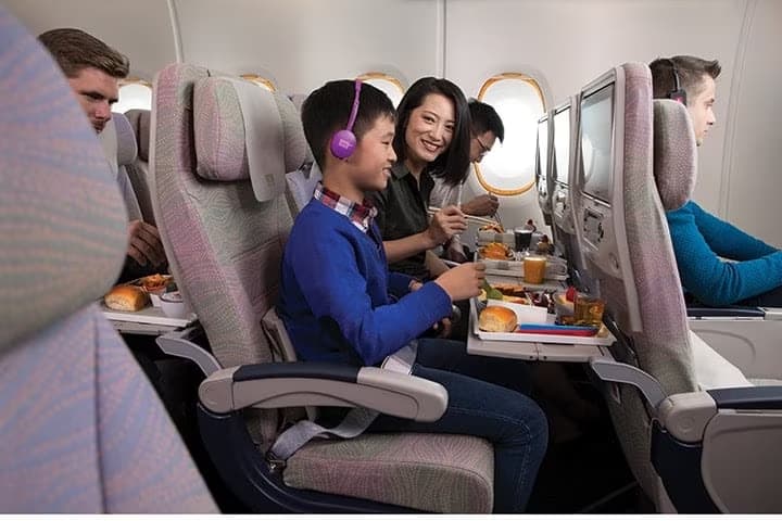 食事をしながら機内エンターテインメントを楽しむ子どもの様子