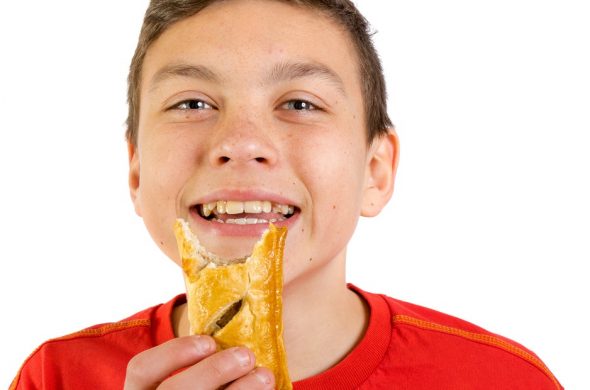 イギリスの名物料理ミートパイを食べる少年