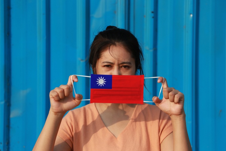 台湾の国旗の柄マスクをもったアジア女性