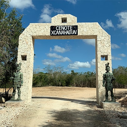 両脇に2体の銅像が立つ、セノーテ・シカナハルトゥンの門