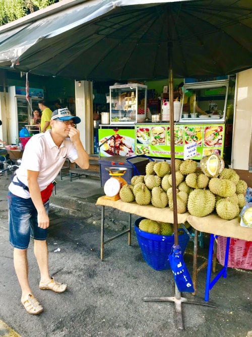 街中のドリアン屋台。切り売り用のドリアンをカット中で、無視できないニオイを放っていました。