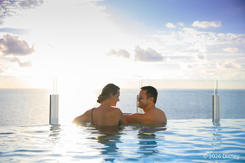 プールに入りながらサンセットを見るカップル